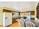 Well-lit kitchen features wooden cabinets, white appliances, and an island with seating at 7245 W 70Th Ave, Arvada, CO 80003