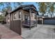 View of brick home with updated windows, covered patio, attached garage, and extended concrete driveway at 1399 Newton St, Denver, CO 80204