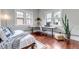 Comfortable bedroom featuring hardwood floors, an L shaped desk, and abundant natural light at 1399 Newton St, Denver, CO 80204