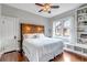 Cozy bedroom with hardwood floors, a natural wood headboard, and a built-in bookshelf by the window at 1399 Newton St, Denver, CO 80204
