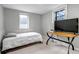 Comfortable bedroom features a wood desk, tv, and a bright window at 1399 Newton St, Denver, CO 80204