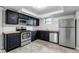 Kitchen with stainless steel appliances, dark wood cabinetry, and tile backsplash at 1399 Newton St, Denver, CO 80204