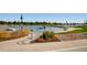 Scenic lakeside view with a paved walkway, lush flowerbed, and boats gently resting on the calm water at 1399 Newton St, Denver, CO 80204