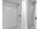 White tiled shower with modern shower head, in a charming bathroom at 1399 Newton St, Denver, CO 80204