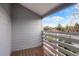 Outdoor balcony with wood decking and slatted railing overlooking a street at 7665 E Eastman Ave # 302B, Denver, CO 80231
