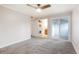 Spacious bedroom with ceiling fan, new carpets, and an adjacent laundry area at 7665 E Eastman Ave # 302B, Denver, CO 80231