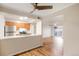Open-concept kitchen with stainless steel appliances, breakfast bar, and wood floors at 7665 E Eastman Ave # 302B, Denver, CO 80231