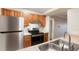 Close-up of kitchen with stainless steel refrigerator and electric stove set in wood cabinetry at 7665 E Eastman Ave # 302B, Denver, CO 80231
