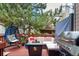 Outdoor back deck with grill, comfortable seating, and a hanging chair with a large shade tree at 1885 S Quebec Way # G 106, Denver, CO 80231