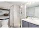 Bathroom with a glass-enclosed shower, vanity with a sink, and open shelving for storage at 1885 S Quebec Way # G 106, Denver, CO 80231