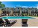 Relaxing community pool surrounded by lounge chairs and well-kept landscaping and a multi-story condo at 1885 S Quebec Way # G 106, Denver, CO 80231