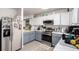 Kitchen with two-tone cabinets, stainless steel appliances, and modern lighting at 1885 S Quebec Way # G 106, Denver, CO 80231