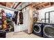 Functional basement laundry room with modern washer and dryer and extra storage shelving and closet at 1885 S Quebec Way # G 106, Denver, CO 80231
