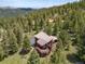 Aerial view of a house in the middle of a forest showing the deck with furniture at 173 Silver Cloud Ln, Boulder, CO 80302