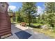 Inviting backyard patio with wooden bench, lush landscaping, and a peaceful wooded backdrop at 173 Silver Cloud Ln, Boulder, CO 80302