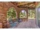 Covered brick balcony with seating, offering beautiful wooded views at 173 Silver Cloud Ln, Boulder, CO 80302