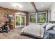 Bedroom with exposed brick, wood floors, and sliding glass door to balcony at 173 Silver Cloud Ln, Boulder, CO 80302