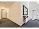 Hallway featuring neutral walls, gray carpet, and a decorative mirror and shelf at 4250 S Olive St # 102, Denver, CO 80237