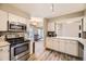 An open kitchen with stainless steel appliances, modern white cabinets, and wood-look flooring, creating a stylish cooking space at 4250 S Olive St # 102, Denver, CO 80237