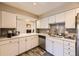 Bright kitchen features white cabinets, stainless steel appliances, and a gray tiled backsplash, giving a clean and modern look at 4250 S Olive St # 102, Denver, CO 80237
