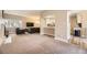 Open-concept living room with comfortable seating, TV, adjacent to a kitchen with breakfast bar at 4250 S Olive St # 102, Denver, CO 80237