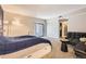 A large main bedroom featuring carpet floors, a navy accent wall, and a sliding door to the patio and large sofa at 4250 S Olive St # 102, Denver, CO 80237