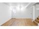 Finished basement with wood-look vinyl flooring, white walls, and multiple doors at 8651 Franklin St, Denver, CO 80229