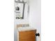 Modest bathroom featuring a wooden vanity with cream countertop, an undermount sink, and a framed mirror at 8651 Franklin St, Denver, CO 80229