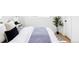 Bright bedroom with neutral tones featuring a plant, stylish rug and comfortable bed with gray patterned quilt at 8651 Franklin St, Denver, CO 80229