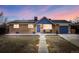 Charming single-story home with a brick exterior, blue accents, solar panels, and a well-lit walkway at 8651 Franklin St, Denver, CO 80229