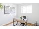 Bright office featuring a modern desk, chair, and decorative artwork, complemented by wood floors and a window at 8651 Franklin St, Denver, CO 80229