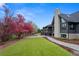 Landscaped backyard with vibrant trees, a spacious lawn, and modern home exterior at 5859 E Ida Pl, Greenwood Village, CO 80111