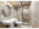 Bathroom with classic fixtures including a pedestal sink, toilet, and tiled shower with glass doors at 5859 E Ida Pl, Greenwood Village, CO 80111