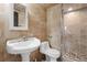 Bathroom with beautiful stone tiling, an elongated toilet, and a glass enclosed shower at 5859 E Ida Pl, Greenwood Village, CO 80111