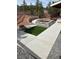 Manicured backyard featuring green lawn and artificial lawn, a walkway, and brick planter at 8229 Red Rock Pl, Larkspur, CO 80118