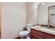 Powder room featuring a toilet, vanity with granite countertop, and decorative mirror at 8229 Red Rock Pl, Larkspur, CO 80118