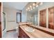 Bright bathroom featuring a large mirror, single sink vanity, and a glass-enclosed shower at 8229 Red Rock Pl, Larkspur, CO 80118