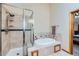 A tiled bathroom featuring a glass-enclosed shower and a luxurious soaking tub with tiled surround at 8229 Red Rock Pl, Larkspur, CO 80118