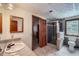 Well-lit bathroom features tiled floor, glass shower, and vanity with a light wood framed mirror at 8229 Red Rock Pl, Larkspur, CO 80118