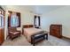 Neutral bedroom with two windows, light-colored carpet, and traditional furnishings at 8229 Red Rock Pl, Larkspur, CO 80118