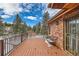 Inviting wood deck with iron railing offering a scenic view of the surrounding trees and landscape at 8229 Red Rock Pl, Larkspur, CO 80118