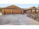 Charming brick home with a large concrete driveway and beautiful wooden garage doors at 8229 Red Rock Pl, Larkspur, CO 80118