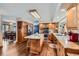 Well-lit kitchen with wood cabinets, stainless steel appliances, an island, granite countertops, and wood floors at 8229 Red Rock Pl, Larkspur, CO 80118