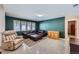 Inviting living room with a large sectional sofa, a patterned rug, and ample natural light at 8229 Red Rock Pl, Larkspur, CO 80118