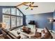 Comfortable living room featuring vaulted ceilings and a large window overlooking the backyard at 8229 Red Rock Pl, Larkspur, CO 80118