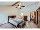 A bright and airy main bedroom featuring a ceiling fan, a large bed, and an ensuite bathroom at 8229 Red Rock Pl, Larkspur, CO 80118