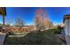 Landscaped backyard with lush green lawn, mature trees, and a charming wooden fence that provides privacy at 1430 Bluefield Ave, Longmont, CO 80504
