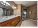 Bright bathroom featuring double sinks, a large mirror, and an arched entryway to the bedroom at 1430 Bluefield Ave, Longmont, CO 80504