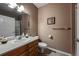 Bathroom with wood vanity, white sink, and white toilet offers a clean and functional space at 1430 Bluefield Ave, Longmont, CO 80504