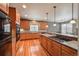 Spacious kitchen features warm wood cabinets, hardwood floors, and a breakfast bar at 1430 Bluefield Ave, Longmont, CO 80504